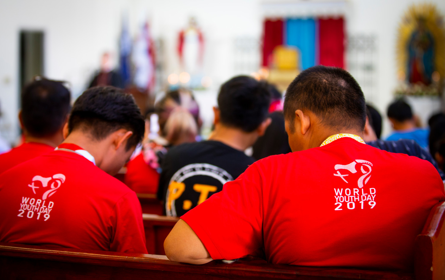 World Youth Day pilgrims bow their heads in pray during a catechesis session lead by Chicago Cardinal Blase J. Cupich at the Parish of Our Mother of Perpetual Help in Panama City Jan. 25, 2019.
